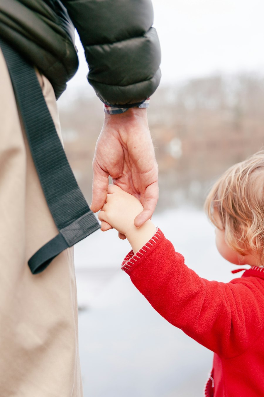 A dad holding his toddler's hand